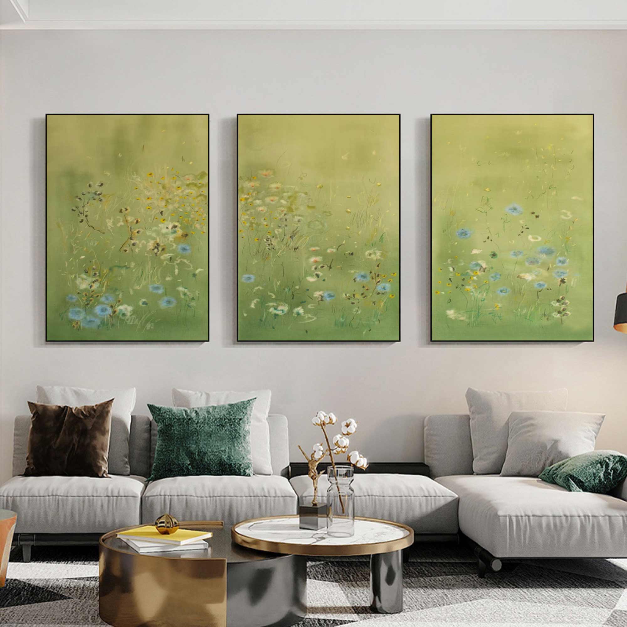 Three green abstract paintings above a gray sofa in a living room.