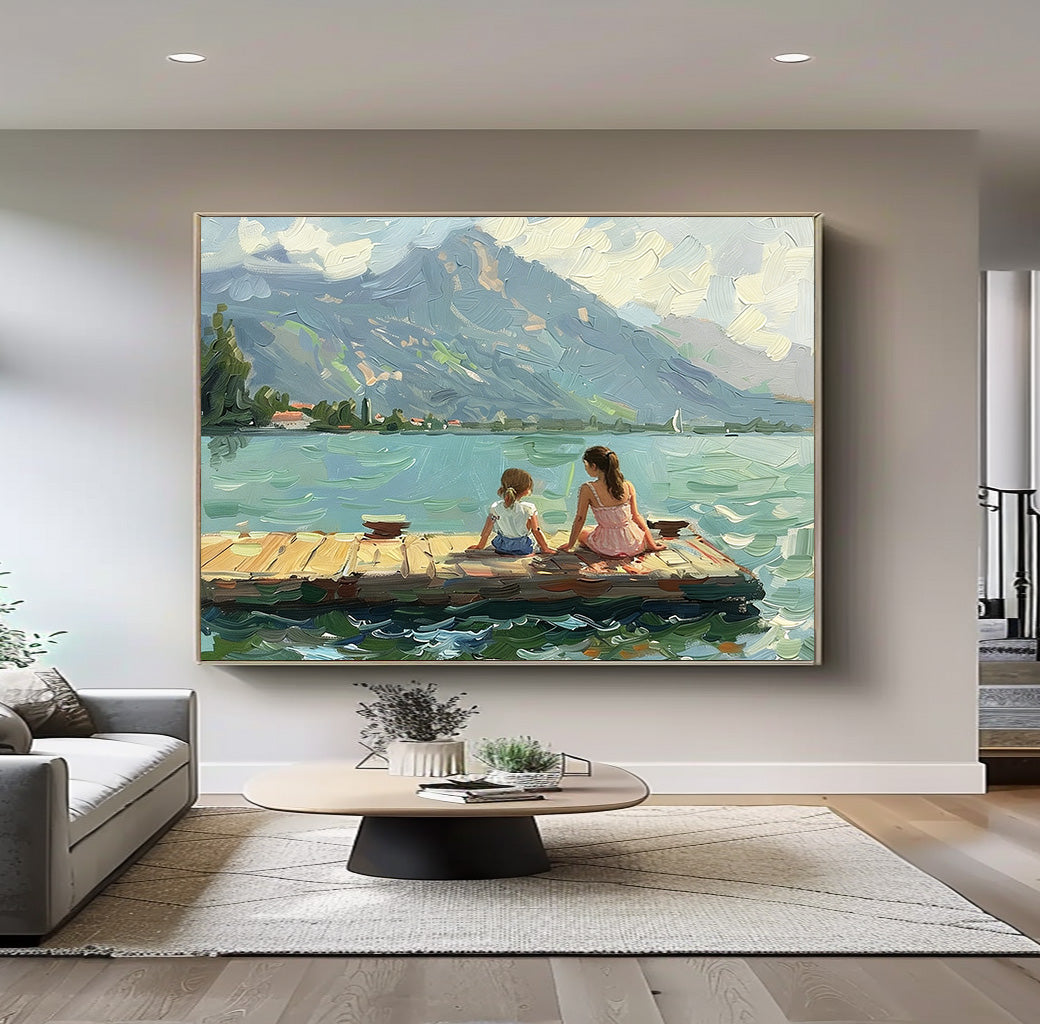 Living room with a painting of two people on a dock over water with mountains in the background.