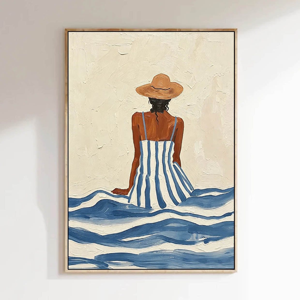 Framed artwork of a woman in a striped dress and hat sitting in water on a textured beige background.